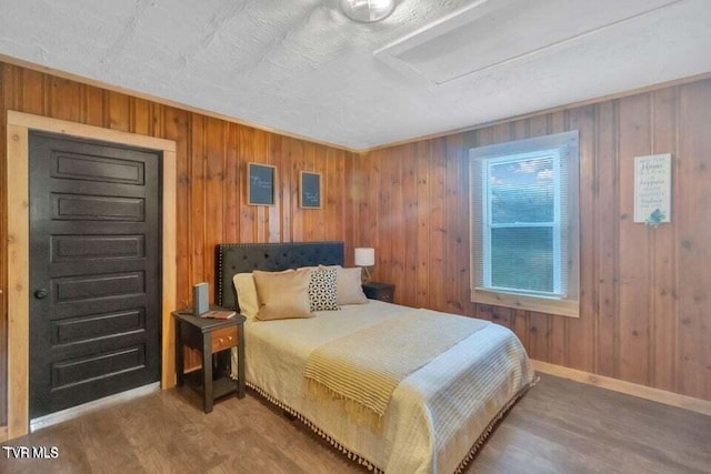 bedroom with wood walls and wood-type flooring