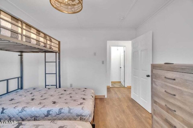 bedroom with ornamental molding and hardwood / wood-style flooring