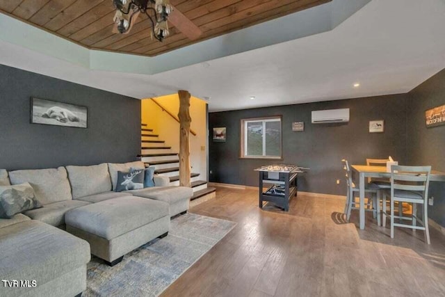 living room with hardwood / wood-style flooring, an AC wall unit, a raised ceiling, and wooden ceiling