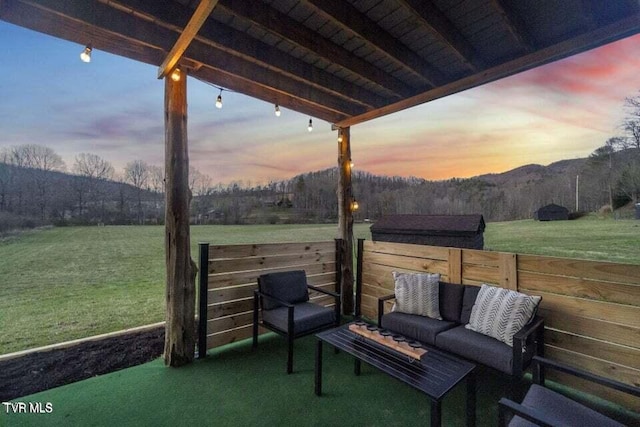 patio terrace at dusk with a yard and outdoor lounge area