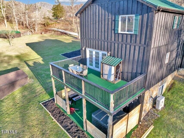 view of home's exterior with ac unit, french doors, and a lawn