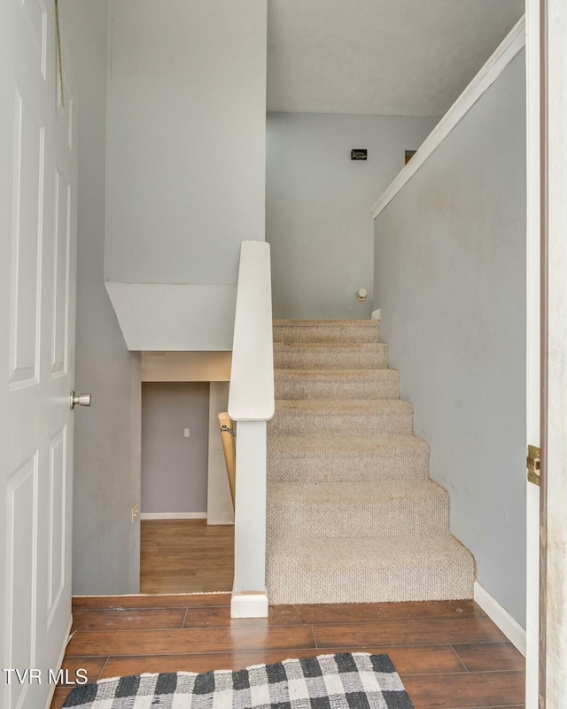 staircase with hardwood / wood-style floors