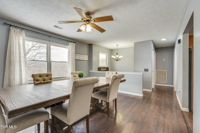 dining area with ceiling fan with notable chandelier, a textured ceiling, and dark hardwood / wood-style floors