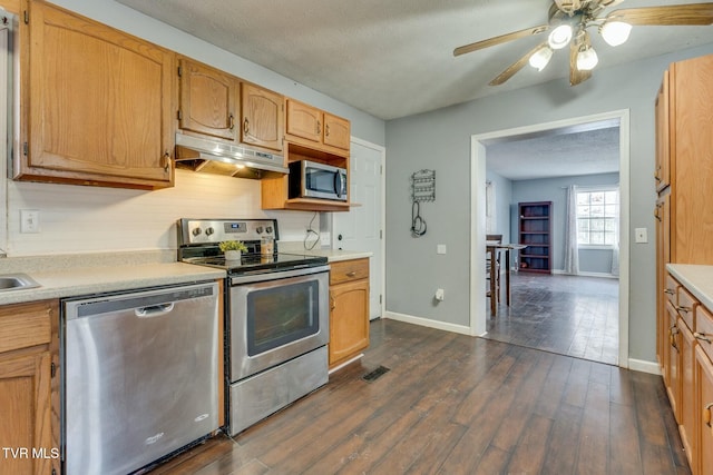 kitchen featuring a textured ceiling, dark wood-type flooring, stainless steel appliances, and ceiling fan