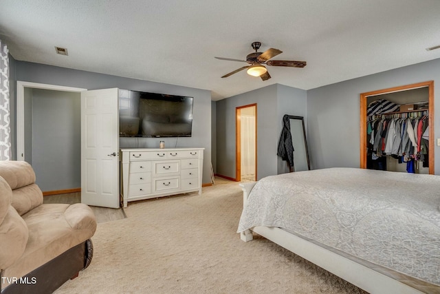 carpeted bedroom featuring ceiling fan, a textured ceiling, and a closet