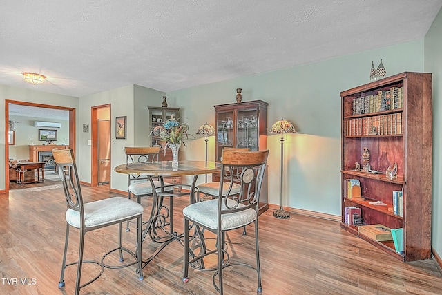 dining area featuring light hardwood / wood-style floors and a textured ceiling