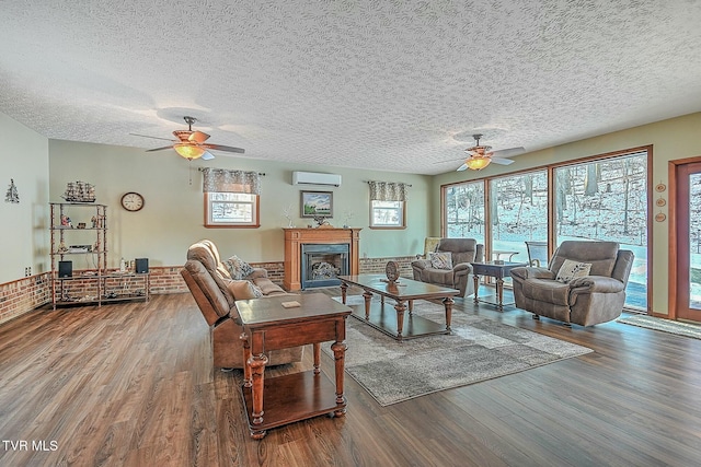 living room featuring hardwood / wood-style flooring, a textured ceiling, and a wall unit AC