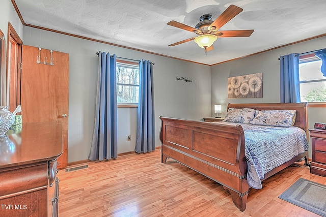 bedroom with ceiling fan, ornamental molding, and light hardwood / wood-style floors