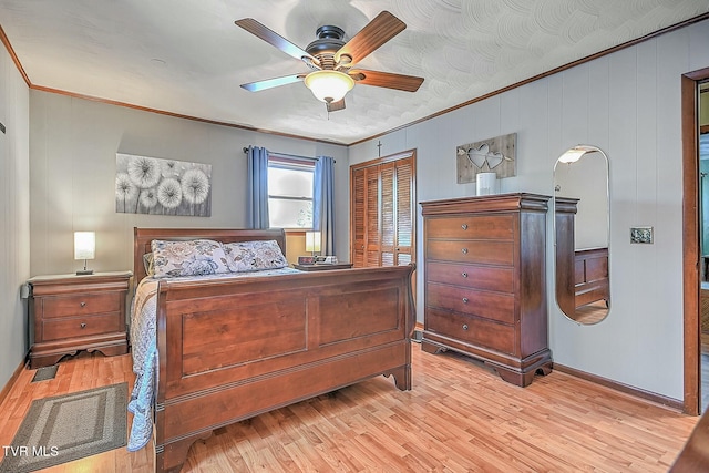 bedroom featuring ceiling fan, light hardwood / wood-style flooring, a textured ceiling, ornamental molding, and a closet