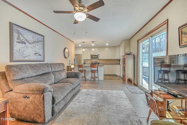 tiled living room with ceiling fan and a textured ceiling