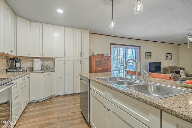 kitchen with dishwasher, white cabinetry, light hardwood / wood-style floors, hanging light fixtures, and stove