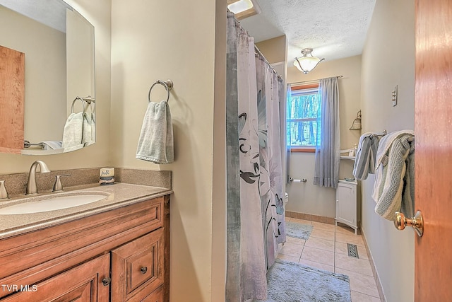 bathroom featuring vanity, tile patterned floors, and a textured ceiling