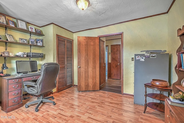 office area featuring light wood-type flooring, ornamental molding, and a textured ceiling