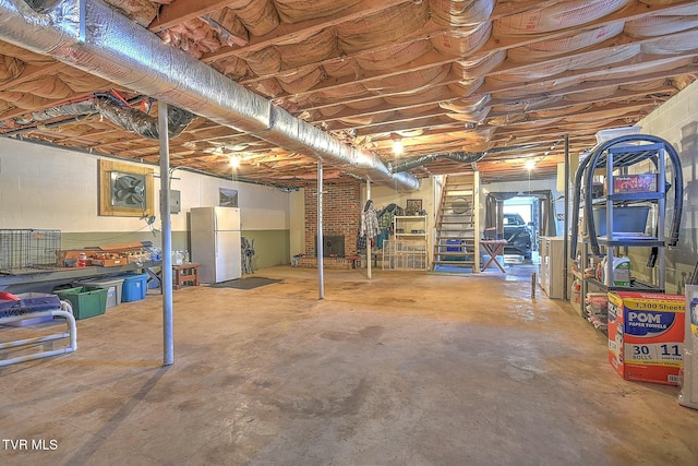 basement featuring white fridge and electric panel