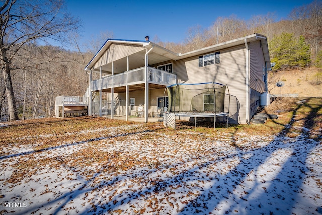 snow covered house featuring a trampoline