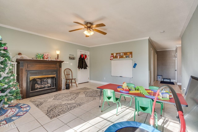 game room with ceiling fan, light tile patterned floors, and ornamental molding