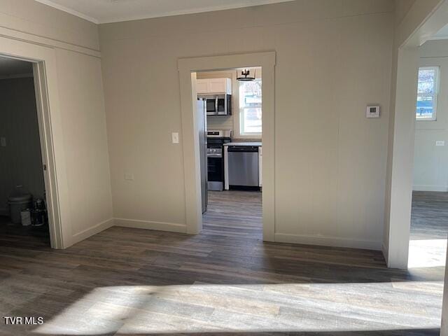 interior space featuring dark hardwood / wood-style floors, plenty of natural light, and ornamental molding