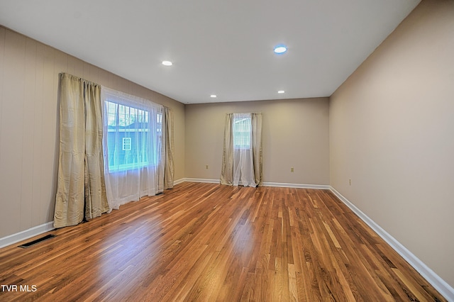 spare room with hardwood / wood-style floors and plenty of natural light