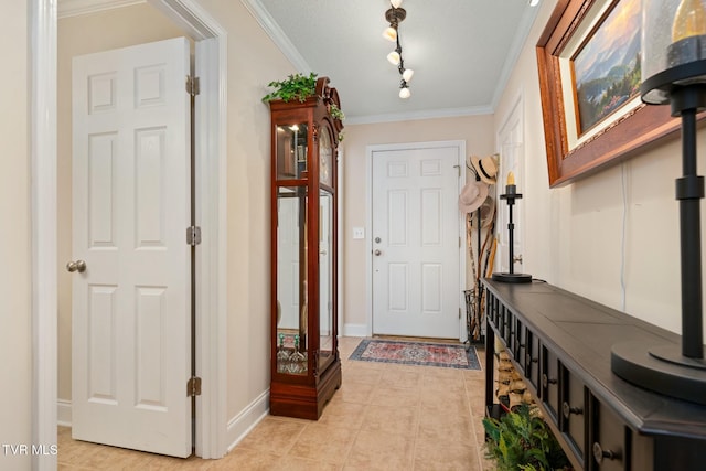 foyer featuring light tile patterned flooring, track lighting, and ornamental molding