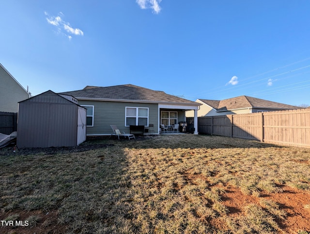 back of property with a yard and a storage unit