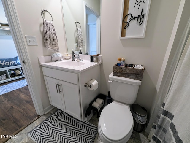 bathroom with toilet, vanity, and hardwood / wood-style floors