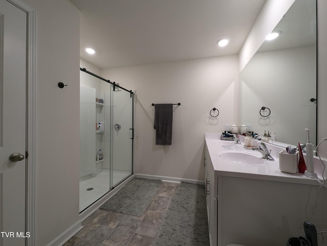 bathroom with vanity and a shower with door