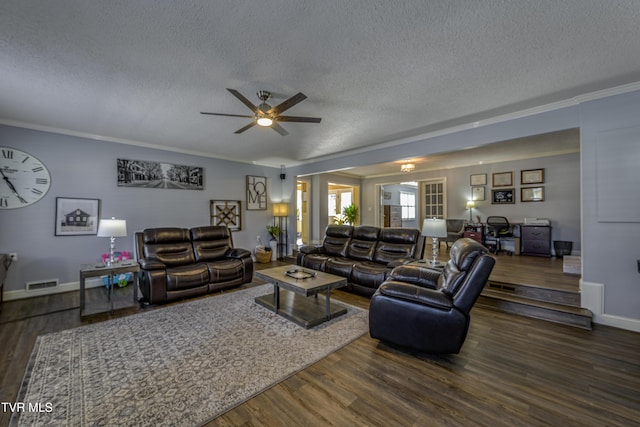 living room with dark hardwood / wood-style flooring, a textured ceiling, ceiling fan, and ornamental molding