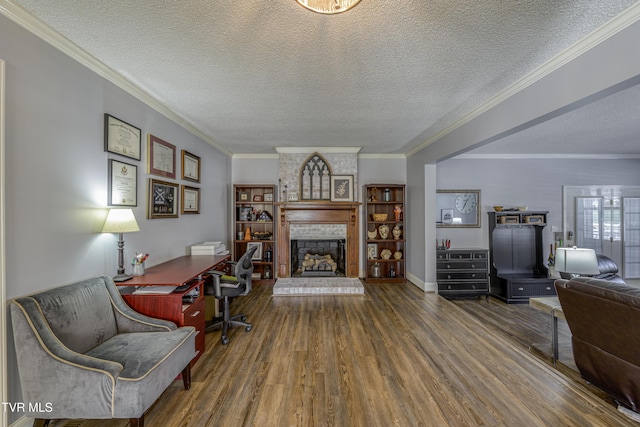 home office with a brick fireplace, a textured ceiling, ornamental molding, and dark hardwood / wood-style flooring