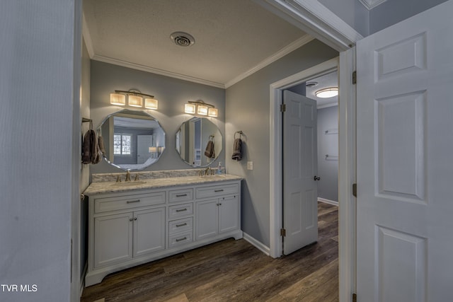 bathroom with crown molding, vanity, and wood-type flooring