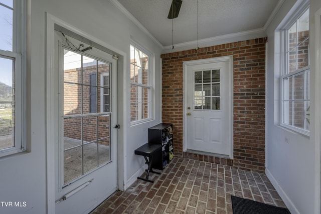 doorway to outside with a textured ceiling and ornamental molding