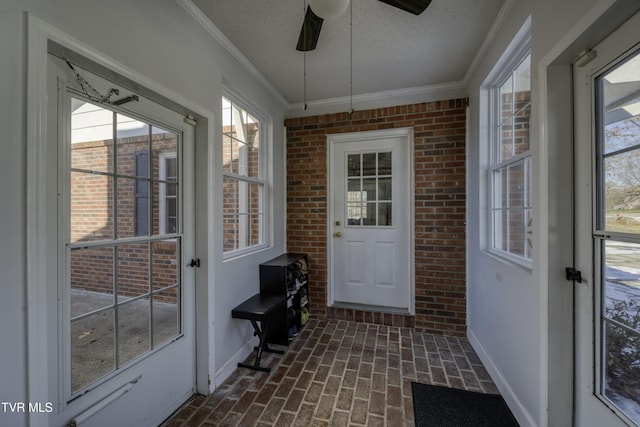 sunroom featuring ceiling fan and plenty of natural light