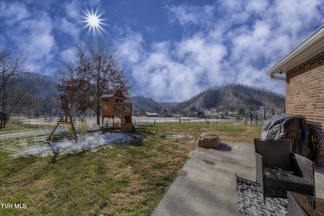 view of yard featuring a playground, a rural view, and a mountain view