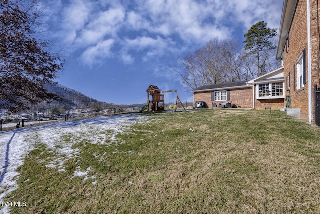 view of yard featuring a playground and a mountain view