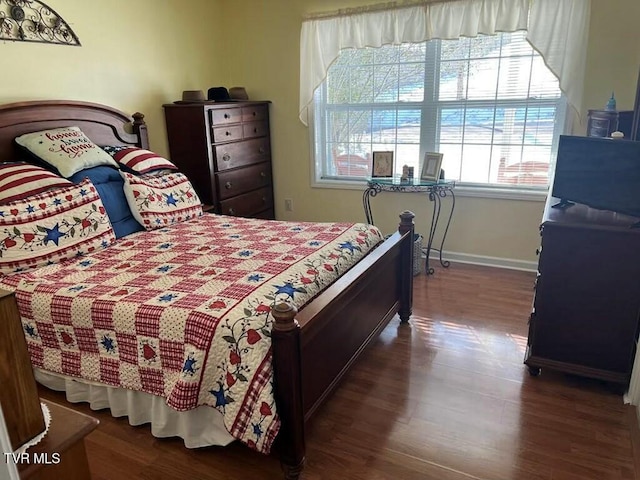 bedroom with baseboards and dark wood finished floors