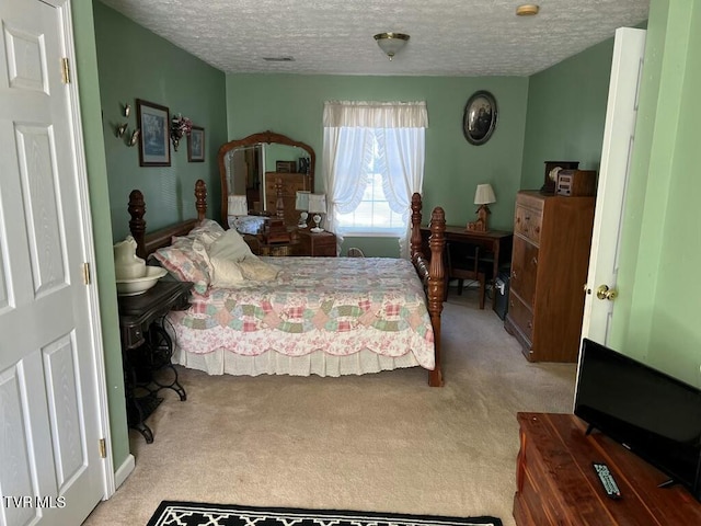 bedroom with light carpet and a textured ceiling