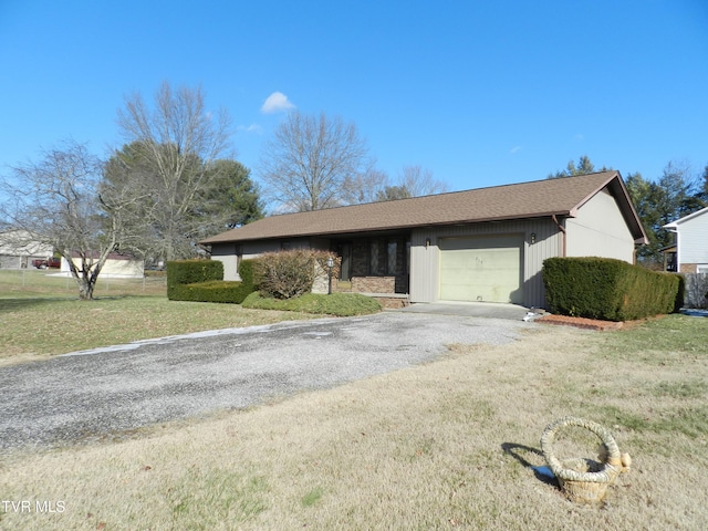 ranch-style house featuring a front yard and a garage