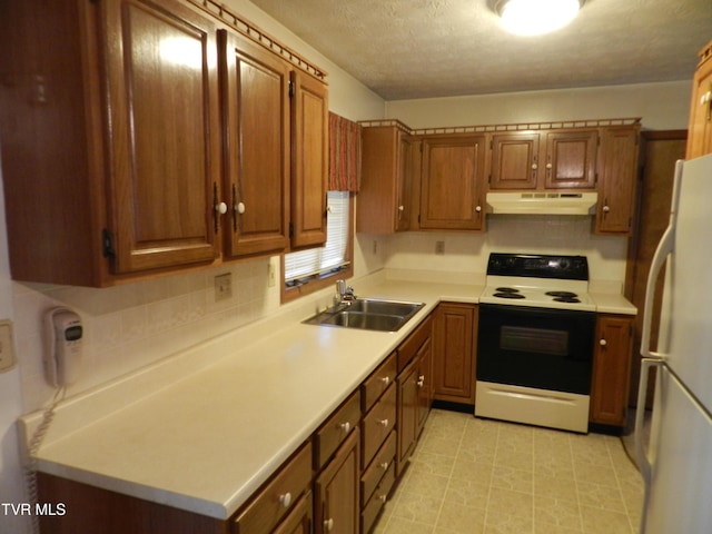 kitchen featuring sink, electric range oven, white fridge, and a textured ceiling