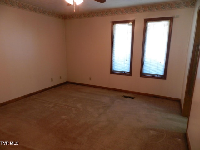 carpeted spare room with ceiling fan