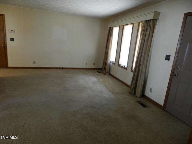 empty room with a textured ceiling and carpet