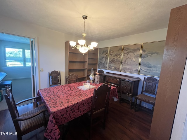 dining room with dark wood-type flooring and a chandelier