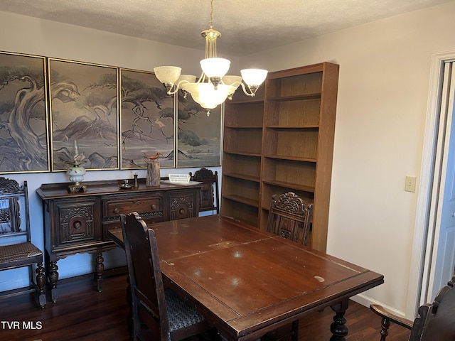 dining room with dark hardwood / wood-style flooring, a textured ceiling, and a chandelier