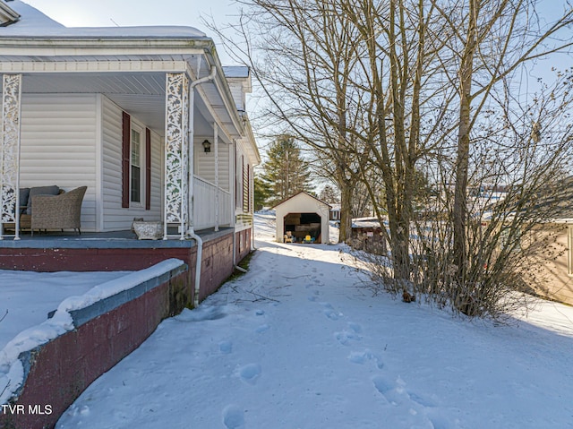 snow covered property with an outbuilding and a garage