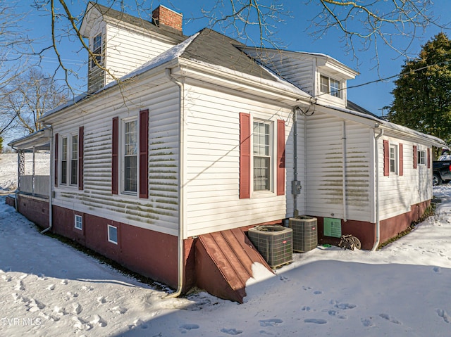 view of snow covered exterior featuring cooling unit