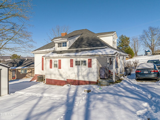 view of snow covered exterior with central AC