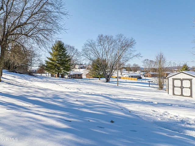 yard covered in snow featuring a storage shed