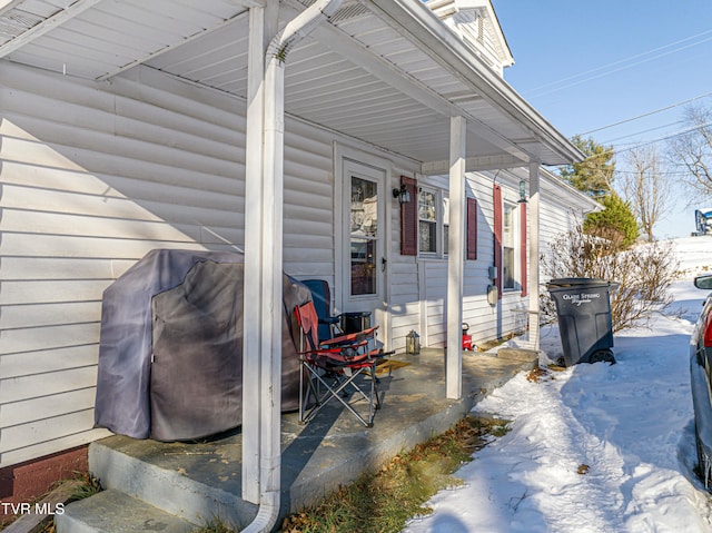 snow covered patio featuring a grill