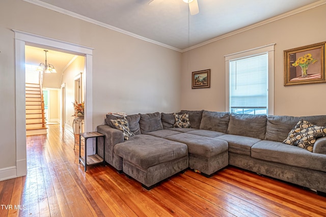 living room featuring ceiling fan with notable chandelier, ornamental molding, and hardwood / wood-style floors