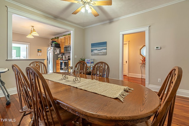 dining space with hardwood / wood-style flooring, crown molding, and ceiling fan