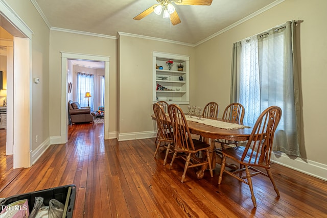 dining room featuring crown molding, dark wood-type flooring, ceiling fan, and built in shelves