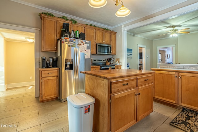 kitchen featuring stainless steel appliances, crown molding, a center island, and ceiling fan